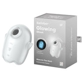 A product image of the Satisfyer Glowing Ghost - White Air Pulse Vibrator, a glow-in-the-dark, double air pulse device with advanced air pulse technology. The vibrator is white with a light blue glow, featuring subtle curves and hand grips. The packaging beside it showcases branding and a picture of the waterproof product glowing.