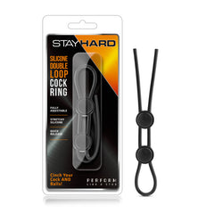 A packaged product labeled "Stay Hard Silicone Double Loop Cock Ring" features a black adjustable silicone double loop with two tightening mechanisms. The package highlights its fully adjustable design, stretchy silicone material, and quick release functionality.
