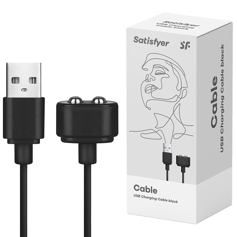 A Satisfyer USB Charging Cable in black is displayed next to its retail packaging, which features line art of a woman's face along with the brand name "Satisfyer" and the product description "USB Charging Cable black". This rechargeable cable, designed for Satisfyer products, includes a standard USB-A connector on one end and a magnetic connector on the other.