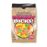 A bag of vibrant, sugar-coated gummy candies shaped like male genitalia. The packaging features playful, bold text that reads "Suck A Bag Of Gummy Dicks!" and describes the naughty lollies as soft, chewy, and sweet & sour.