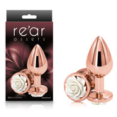 The "Rear Assets Rose - Medium - Rose Gold 8.9 cm Metal Butt Plug" features elegant packaging and product imagery, showcasing a polished metallic finish complemented by a decorative white rose at the base. This ensures both an elegant appearance and body-safe use in anal toys.