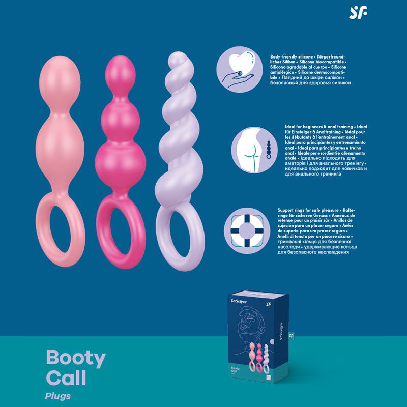 Image showing three silicone anal bead butt plugs of varying shapes and colors (pink, fuchsia, and light purple) with ring handles. Crafted from soft silicone for comfortable anal training, each product has descriptive text in English and another language. A product box at the bottom reads "Satisfyer Booty Call Anal Bead Butt Plug Set.