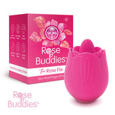 A pink Skins Rose Buddies - The Rose Flix - USB Rechargeable Flicking Rose Stimulator stands next to its red and pink packaging box, which is labeled with the product name. The box highlights features such as 20 settings, USB charging, a waterproof design, and body-safe silicone—ideal for clitoral play—with floral accents.