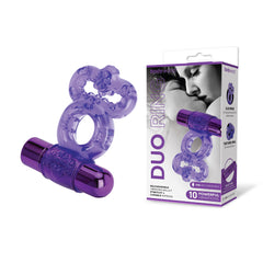 A purple Rechargeable Duo Cock Ring with a dual textured design is displayed next to its packaging. The packaging features a black-and-white image of a couple embracing and includes text describing the product's features, such as being USB rechargeable with 10 powerful vibrations.