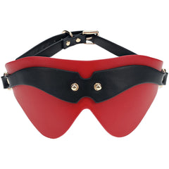 The OUCH! Milan Collection - Blindfold features a sleek, curved design in black and red bonded leather. It fits comfortably over the eyes, secured by an adjustable strap with metal buckles. Two metallic rivets on the front add a touch of high-fashion elegance.