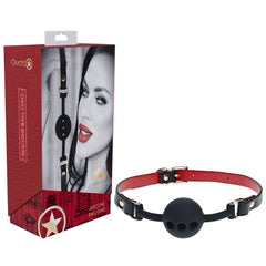 A black silicone ball gag with a red and black adjustable strap from the OUCH! Milan Collection - Silicone Ball Gag lineup is shown next to its packaging. The package features a close-up image of a person with red lips, partial face visible, and the text "OUCH! Silicone Ball Gag." Perfect for your next naughty game.