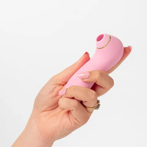 Hand holding a pink electronic device against a white background