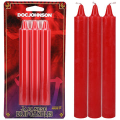 A package of Japanese Drip Candles - Red by Doc Johnson is displayed. Next to the unopened package, the three cylindrical red candles with exposed wicks are showcased, clearly highlighting their vibrant color and shape, ideal for hot wax play. The packaging features an eye-catching purple and red design.