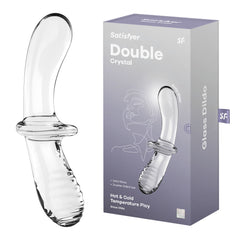 The image features a glass dildo named "Satisfyer Double Crystal Glass Dildo" displayed alongside its packaging. The clear dildo boasts a curved, smooth texture with ridges at the base. The packaging highlights features like "Solid Glass," "Double-sided Use," and "Hot & Cold Temperature Play.