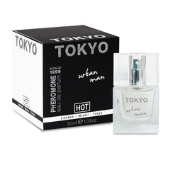 A bottle of "Hot Pheromone Tokyo - Urban Man" fragrance by HOT, designed with pheromones for enhanced sexual appeal, includes a sleek black box featuring "TOKYO" in bold letters on top. The clear glass bottle, labeled "Tokyo Urban Man," contains 30 mL (1.0 fl oz) of French perfume.