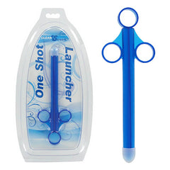 A blue plastic CleanStream One Shot Launcher - Blue Lube Shooter, resembling a syringe with a T-shaped top, packaged in a white and blue plastic case labeled "XL One Shot Lubricant Launcher". The device features three circular finger grips designed for hygienic and one-handed ease of use.