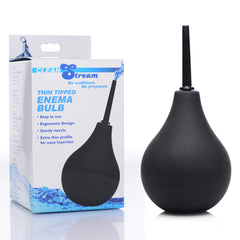 Image of the CleanStream Thin Tip Silicone Enema Bulb in black, placed beside its packaging. The packaging highlights a photo of the enema bulb and lists features like "easy to use," "ergonomic design," "sturdy nozzle," and an "extra thin tip for easy insertion." The brand name "Clean Stream" is visible, emphasizing its body-safe silicone construction.