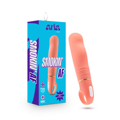 A vibrant ocean blue box showcasing the text "ARIA by blush" and "SMOKIN' AF" alongside an image of the product, a coral-colored, rounded Aria Smokin' AF Vibrator with a looped handle at the base. The toy, designed for G spot stimulation and equipped with Rumble Tech motor, is displayed standing upright next to its packaging.