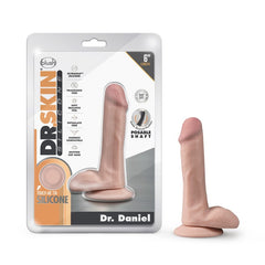 Packaging for the Dr. Skin Silicone "Dr. Daniel" 6-inch realistic dildo by Blush. This body-safe silicone product features a posable shaft and suction cup base, with packaging that highlights qualities like fragrance-free, soft feel, and harness compatibility.