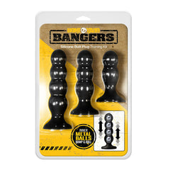 Packaging for the Boneyard Bangers Butt Plug Training Kit, featuring three black, graduated weighted butt plugs with internal metal balls. The packaging highlights the bump and roll feature of the metal balls inside each plug, ideal for enhancing anal play.