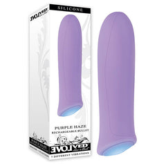 A purple silicone rechargeable bullet vibrator is displayed next to its packaging. The predominantly white box showcases an image of the waterproof device and includes text reading "Evolved Purple Haze" and "7 Powerful Vibrations," accompanied by branding details.