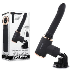 The "Evolved TOO HOT TO HANDLE Machine Vibrator" comes equipped with a black silicone attachment and striking gold accents. This innovative device boasts seven speeds and functions, a vibrating shaft, and a heating feature, all supported by a suction cup base for stability. The product packaging along with a side view of the machine can be seen in the background.