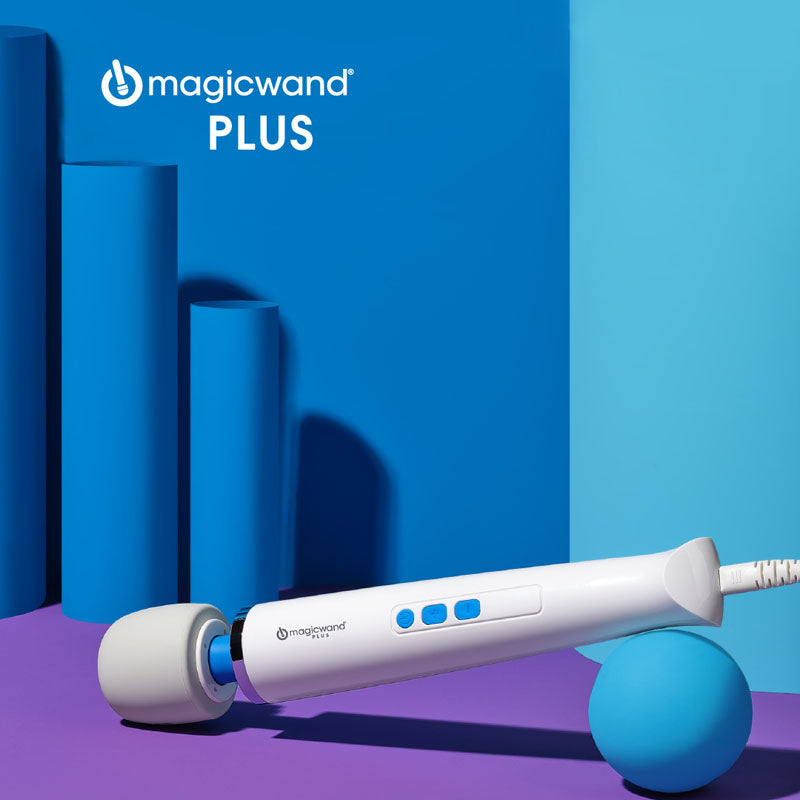 A white Magic Wand Vibrator Plus with blue buttons lies diagonally on a purple and blue background. With its rounded head delivering deep rumbly vibrations, the branding is visible. Blue cylindrical shapes and a blue ball adorn the background.