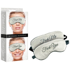 The Fuck Me/Fuck You Reversible Blindfold is displayed both inside and outside its packaging. One side of the silk blindfold features the phrase "Fuck Me," while the other side displays "Fuck You," both embroidered in elegant script. The packaging includes an image of a smiling person wearing the blindfold.