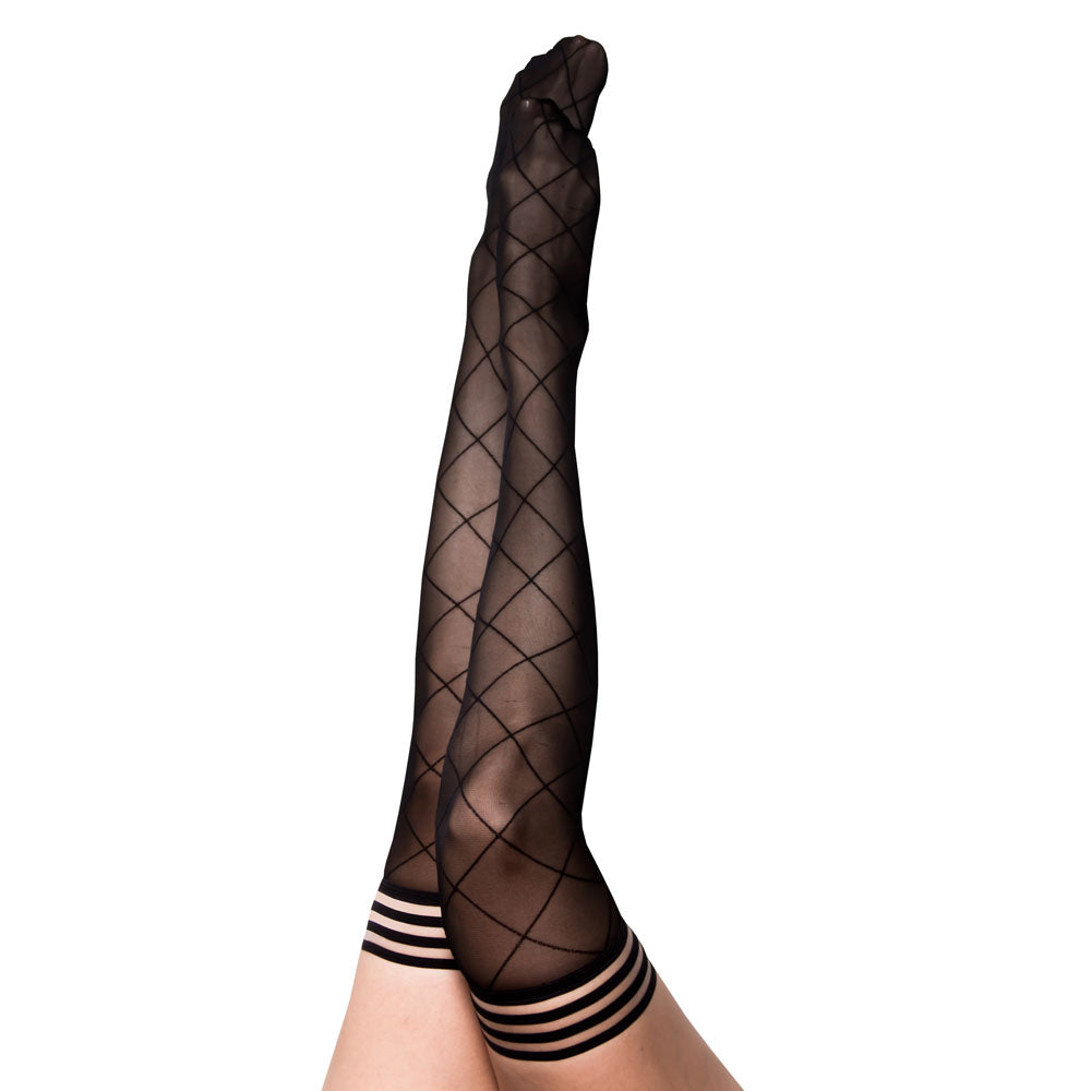 A person is wearing a pair of Kixies ANNA Sheer Black Diamond Thigh Highs featuring a crisscross diamond pattern and striped tops. The legs are raised against a plain white background, highlighting the no-slip-grip feature that ensures they stay securely in place.