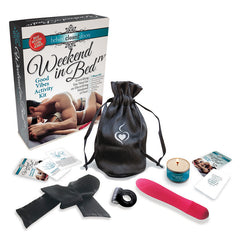 The "Behind Closed Doors - Weekend In Bed IV" kit is displayed, featuring a black drawstring bag, a pink vibrator, a black cock ring, black bondage tape, a candle, and various cards and packets. The packaging showcases an intimate couple enjoying sensual rub-downs.