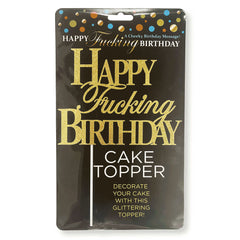 A package for the "Happy Fucking Birthday Cake Topper" featuring glittering gold text that reads "Happy Fucking Birthday." The packaging is primarily black with multicolored confetti accents at the top, and the bottom includes additional text saying, "Decorate your cake with this glittering topper!