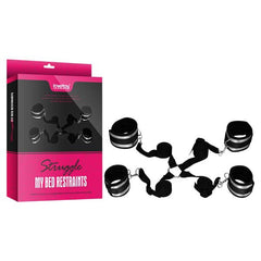 Image showing the Struggle My Bed Restraints kit with black padded cuffs, designed to secure wrists and ankles, connected by adjustable straps. The product is displayed alongside its packaging, which is pink and black with the product name "Struggle My Bed Restraints" and images of the restraints.