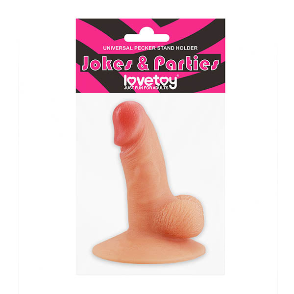 A product packaging for a "Jokes & Parties" item, labeled "Jokes & Parties Universal Pecker Stand Holder" by the brand "LoveToy." This Hens party gift, made from premium silicone, features a realistic, flesh-toned novelty item with a suction-cup base suitable as a playful stand for phones or tablets. The label includes the phrase "Just Fun for Adults.