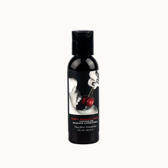 A black bottle labeled "Edible Massage Lotion - Cherry 60ml" features an image of lips holding a cherry by its stem. Infused with nutrient-rich oils, the bottle contains 2 fluid ounces (60 milliliters) of luxurious product perfect for sensual massages.