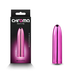 A small, pink, bullet-shaped adult toy is displayed next to its black and pink packaging. The packaging reads "Chroma Petite Bullet Vibrator - Pink" and "rechargeable" on the front, highlighting the premium ABS material known for durability. With a metallic finish and water-resistant feature, the "nsnovelties" branding is prominently featured at the bottom.