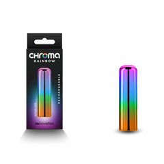 A multicolored cylindrical object, resembling a rainbow pattern, sits next to its packaging. The box displays the same object and has the text "CHROMA RAINBOW," "RECHARGEABLE," and "WATER RESISTANT" written on it. The brand "nsnovelties" is visible at the bottom of the box, showcasing their latest product: Chroma Rainbow Vibrator - Small.