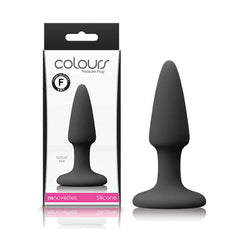 The image displays a black Colours Pleasures Butt Plug from the brand "Colours." The silicone plug, featuring a flared base, is shown both inside and outside of its packaging. The packaging also indicates it is from "nsnovelties" and marked with an "F". These silicone plugs are available in various sizes.