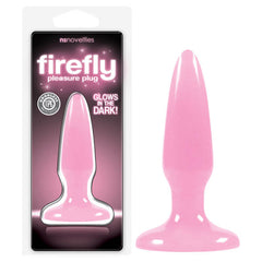 Image of a "Firefly Pleasure Butt Plug" in pink. The product, depicted inside its packaging, showcases features such as "glows in the dark" and "odorless TPE." The glowing plug itself is standalone to the right of the packaging. Crafted from body-safe materials, this TPE plug ensures both safety and pleasure.