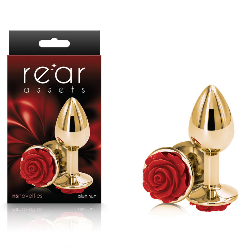 Packaging and presentation of the Rear Assets Rose - Small - Gold 7.6 cm Metal Butt Plug with Red Rose Base from Rear Assets. The product, which features a gold-colored, chrome-plated body and a red rose-shaped base, is depicted both inside and outside its box. The packaging background boasts a dark floral design, emphasizing the elegance of these lightweight, body-safe anal toys.