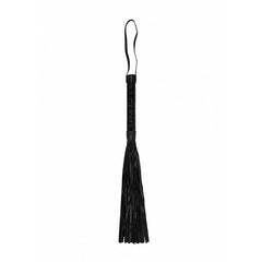The Ouch! Luxury Diamond Whip in black features a braided handle and multiple leather tassels, complete with a loop for hanging or securing around the wrist. The BDSM whip is set against a plain white background.