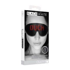 Packaging for the OUCH! Black & White Bonded Leather Eye-Mask ''Ouch'' with elastic straps. The box features an image of a person wearing the eye mask with "Ouch" printed on it, creating anticipation. A badge indicates it as "BEST FETISH BRAND OF THE YEAR.