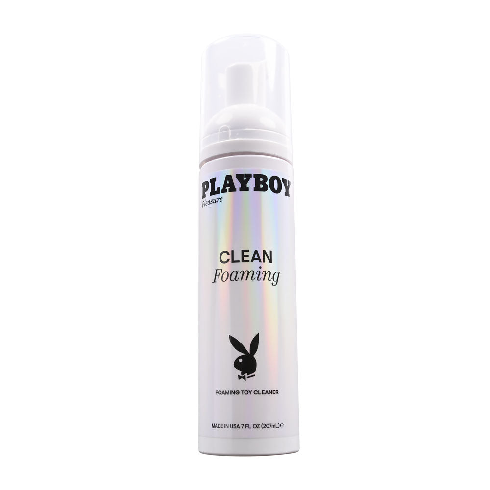 A white cylindrical container of "Playboy Pleasure CLEAN FOAMING" toy cleanser with a holographic sheen. The bottle features the Playboy logo, a bunny silhouette, and a pump dispenser on top. This gentle formula is 7 fl oz and labeled as "Made in USA.