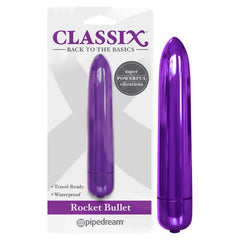 An elongated, shiny purple Classix Rocket Bullet Vibrator is showcased next to its packaging. The package displays "CLASSIX: Back to the Basics" and highlights features such as "Discreet Size," "Waterproof," and "Super Powerful Vibrations." This model is by Pipedream.