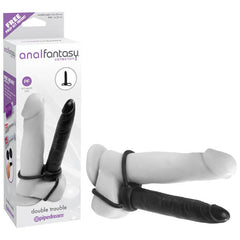 A product image of the Anal Fantasy Collection's "Double Trouble Cock Ring Strap on" by Pipedream. The box showcases the product in white and black, featuring a main dildo and a smaller anal probe attached with harnesses. Ideal for double penetration and enhanced anal stimulation, the product is displayed both inside and outside its packaging.