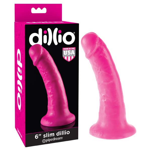 A bright pink six-inch Dillio 6'' Slim dildo with a flared, suction-cup base is displayed next to its matching packaging. The packaging features the same dildo image and notes that it is "Made in the USA" by Pipedream. The dildo has a smooth, curved shape and is hypoallergenic for safe use.