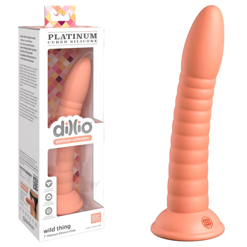 A ribbed, peach-colored silicone dildo with a rounded tip and a suction cup base is pictured next to its packaging. Made from platinum-cured silicone, the packaging is labeled "Platinum Silicone" and displays the product through a transparent window. The product name is "Dillio Platinum Wild Thing - Peach".