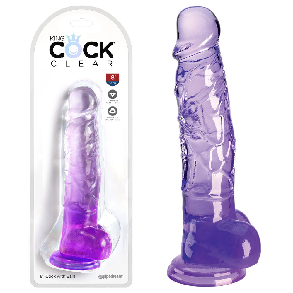 Image of the King Cock Clear 8" Cock with Balls – Purple, featuring a lifelike design with realistic details, including balls and a suction cup base. The clear, purple dildo by Pipedream is displayed both inside its transparent packaging and standing upright outside of it.