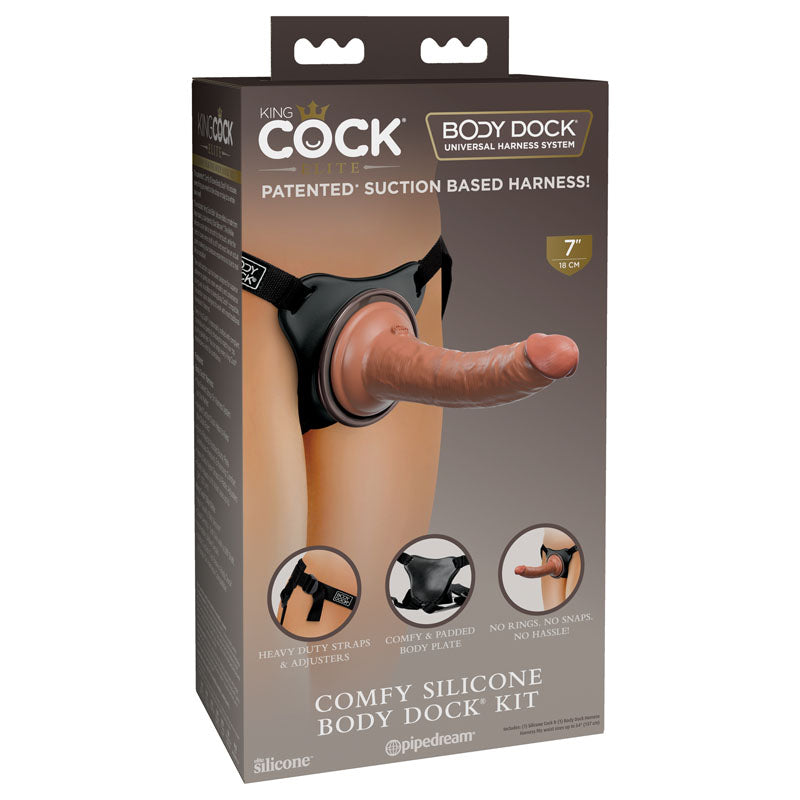 Box of the King Cock Elite Comfy Silicone Body Dock Kit. Features an image of a silicone attachment and harness worn over a person's underwear. Below, there are small images showing close-ups of the heavy-duty straps, comfy padded body plate, and superior adherence suction cup.