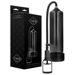 A transparent black cylindrical device with a handle is shown next to its sleek black packaging box. The box displays the product name "Pumped Comfort Beginner Penis Pump - Black" and the branding "Pumped" with a diamond logo near the top. This effective vacuum erection device offers an advanced solution for erectile dysfunction treatment.