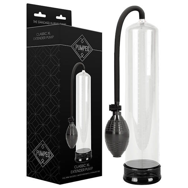 The Pumped Classic XL Penis Extender Pump - Clear, featuring a transparent cylindrical design, a black hand pump, and a flexible tube, is shown next to its packaging. The packaging is predominantly black with white text and graphics, showcasing an image of the extender pump.