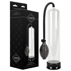 The Pumped Classic XL Penis Extender Pump - Clear, featuring a transparent cylindrical design, a black hand pump, and a flexible tube, is shown next to its packaging. The packaging is predominantly black with white text and graphics, showcasing an image of the extender pump.