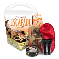 A gift set titled "Sensual Escapade Surprise Bag" featuring a blindfold, a game spinner, two tubes of body chocolate, and a massage candle. The packaging shows a couple in an intimate pose with the candle lit in the background.