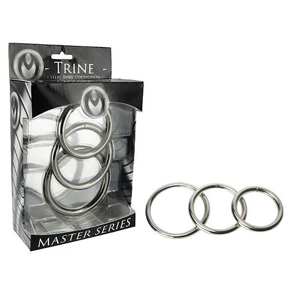Image of a product packaging containing three metal rings from the "Master Series Trine Steel Ring Collection." The packaging displays the brand's name "TRINE" and shows the Master Series Trine Steel Ring Collection on the front. Next to the packaging, the same three steel cock rings are shown outside the box for display.