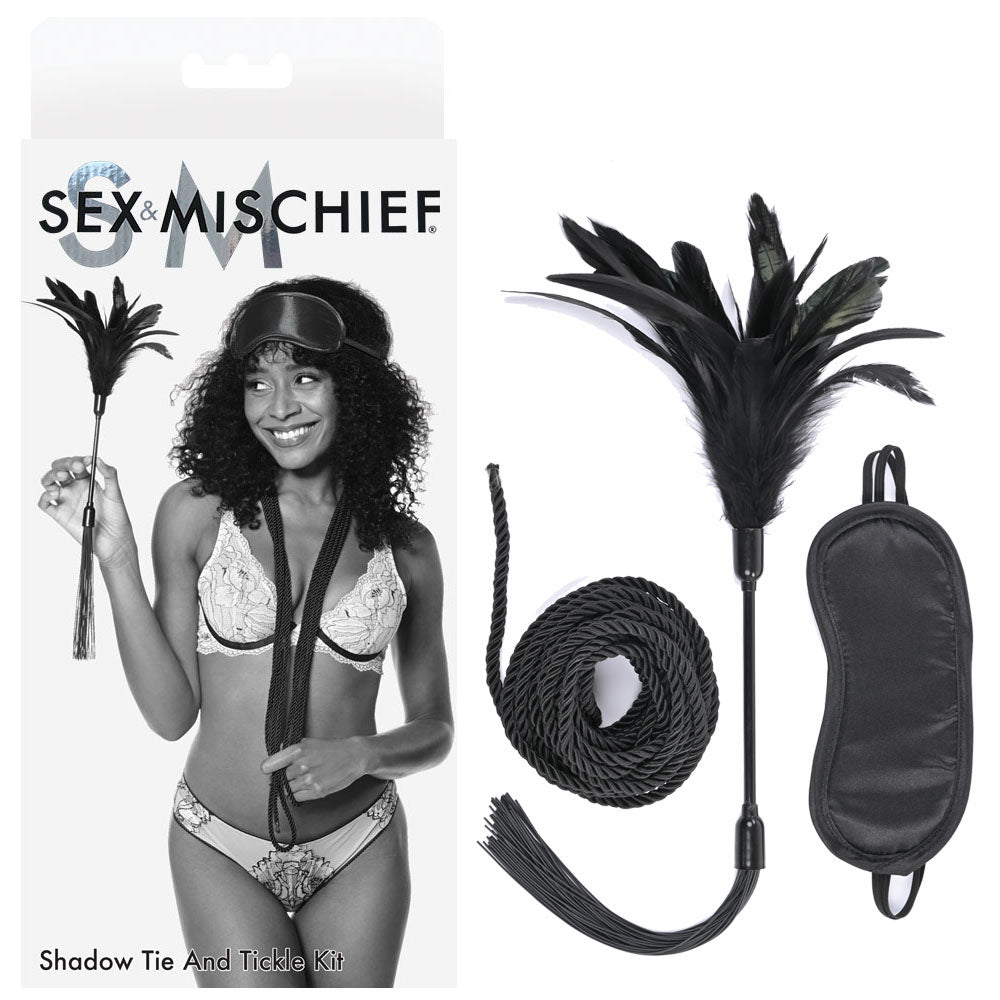 A product image featuring the Sex & Mischief Shadow Tie and Tickle Kit. This kit comprises a feather tickler, black rope, and blindfold designed for sensory play. The packaging displays a model in lingerie using the tickler, with the product brand name prominently displayed at the top.