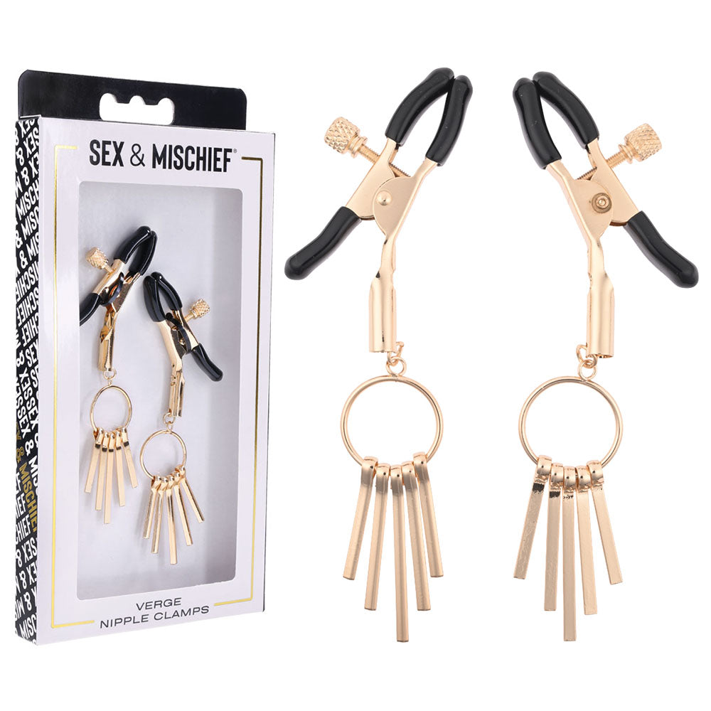A pair of gold-colored adjustable clamps with dangling metal fringes are displayed next to their packaging. The box, named "Sex & Mischief Verge Nipple Clamps," includes a clear window that reveals the kink accessories inside.